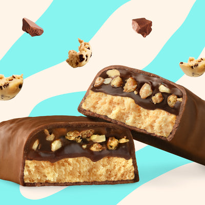 Box of N!CK'S Crispy Cookie Protein Bars (12-pack), with a bar unwrapped and cut to show the filling. Highlights 16g protein and "no added sugar" for a keto snack.