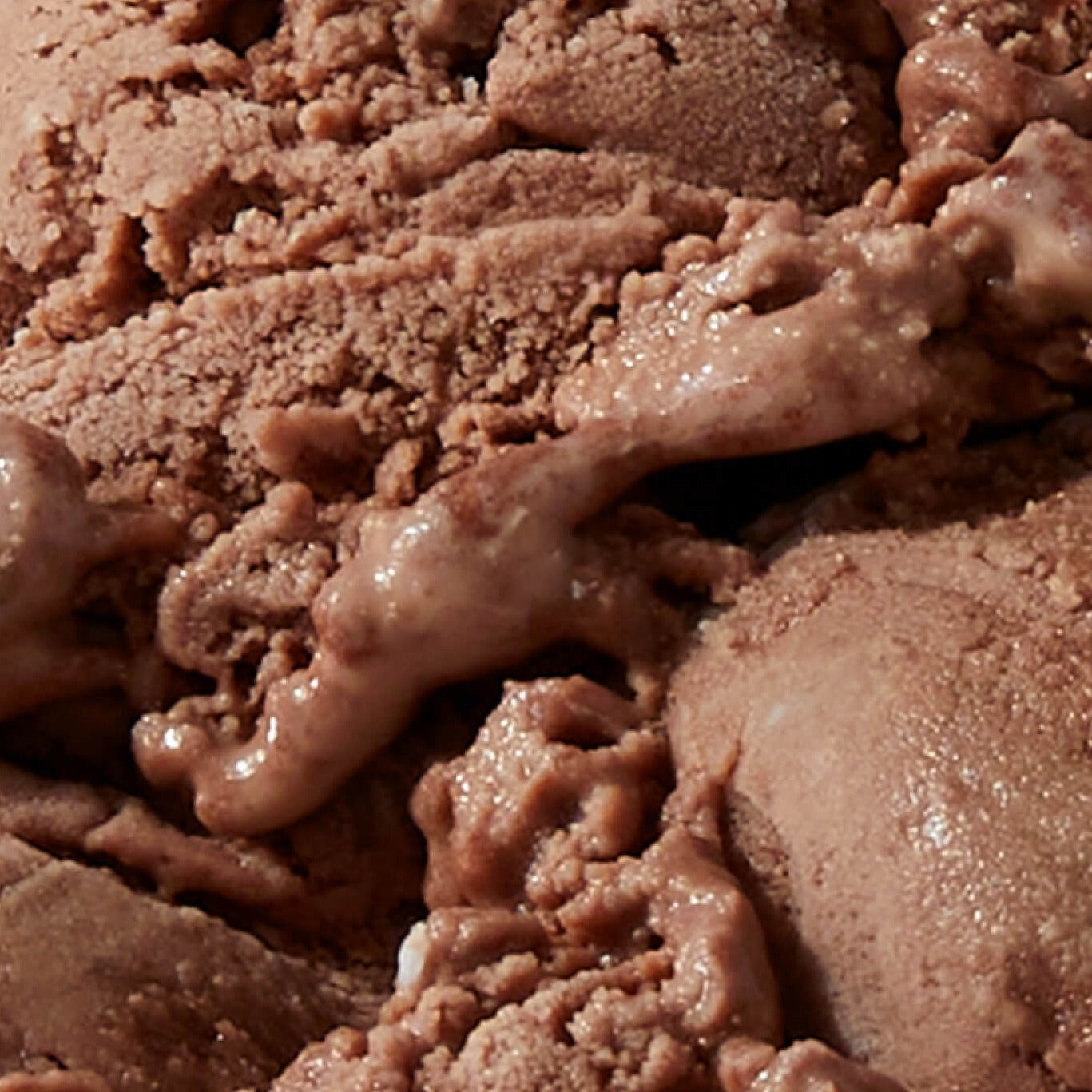 Extreme close-up texture shot of N!CK'S Chocolate light ice cream, showing a rich, smooth-looking chocolate ice cream texture.